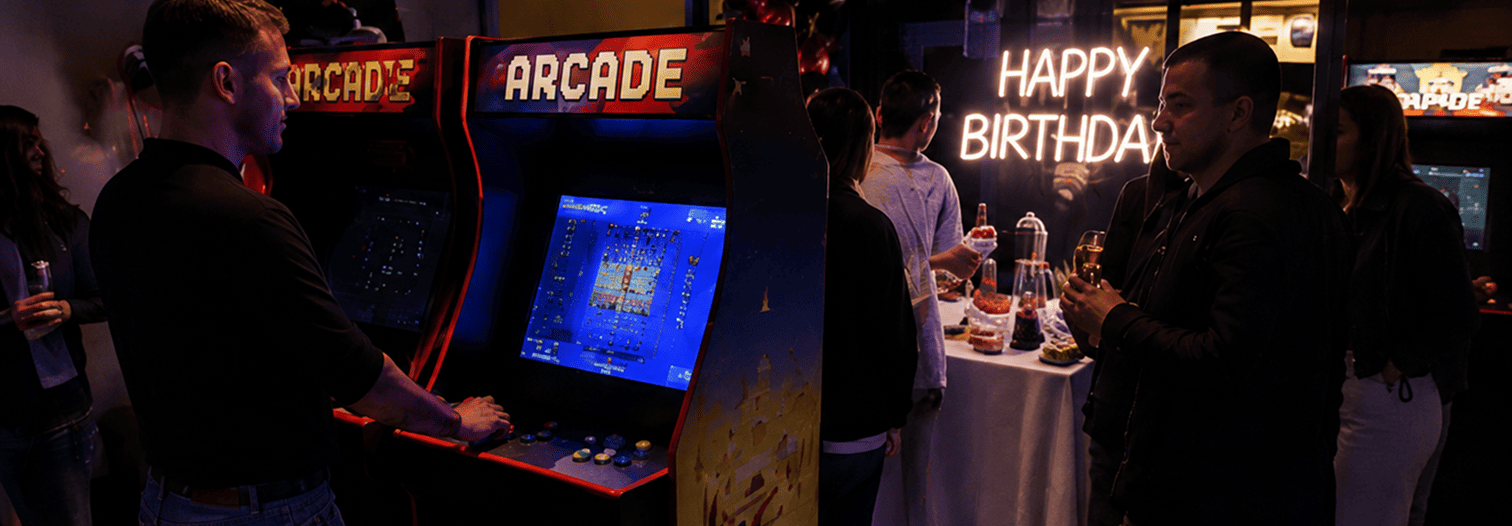 Fila di quattro cabinati arcade in una sala aziendale durante un evento team building